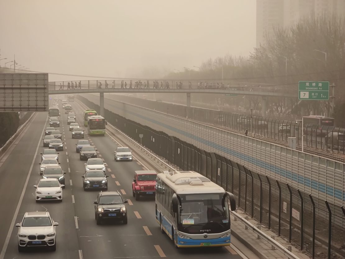 Cars drive in low-visibility through a sandstorm on March 22, 2023 in Beijing, China.