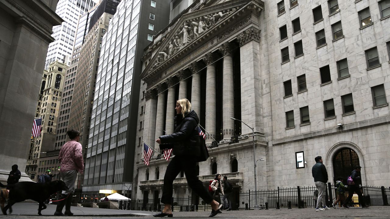 People pass the front of the New York Stock Exchange in New York, on Wednesday, March 22, 2023.