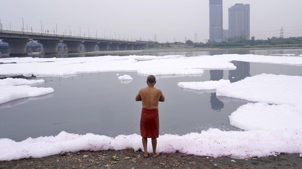 A man performs rituals in the river Yamuna laden with toxic foam from industrial and domestic discharge, in New Delhi, India on March 19, 2023. 