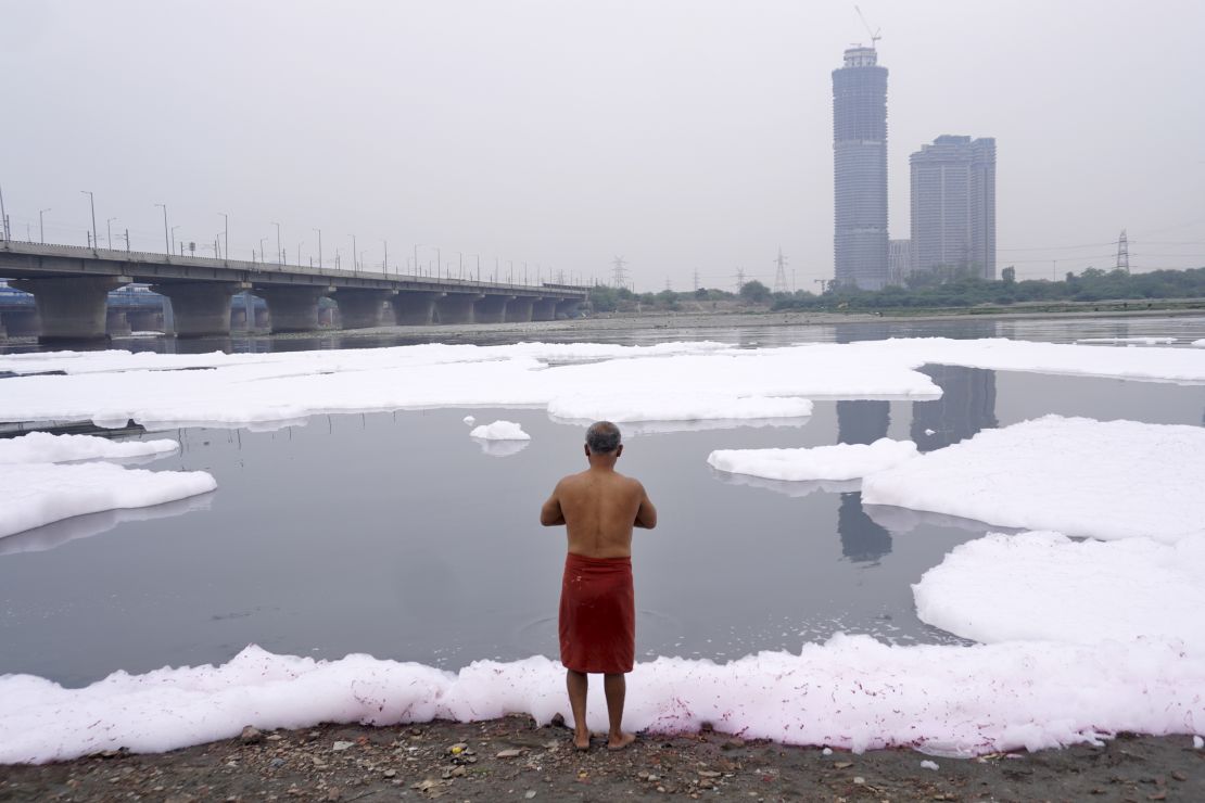 A man performs rituals in the river Yamuna laden with toxic foam from industrial and domestic discharge, in New Delhi, India on March 19, 2023. 
