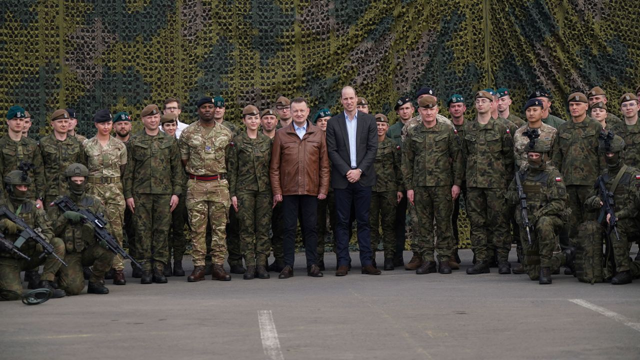 El príncipe William y el viceprimer ministro y ministro de Defensa de Polonia, Mariusz Blaszczak (centro izquierda), posan para una foto grupal con las fuerzas británicas y polacas.