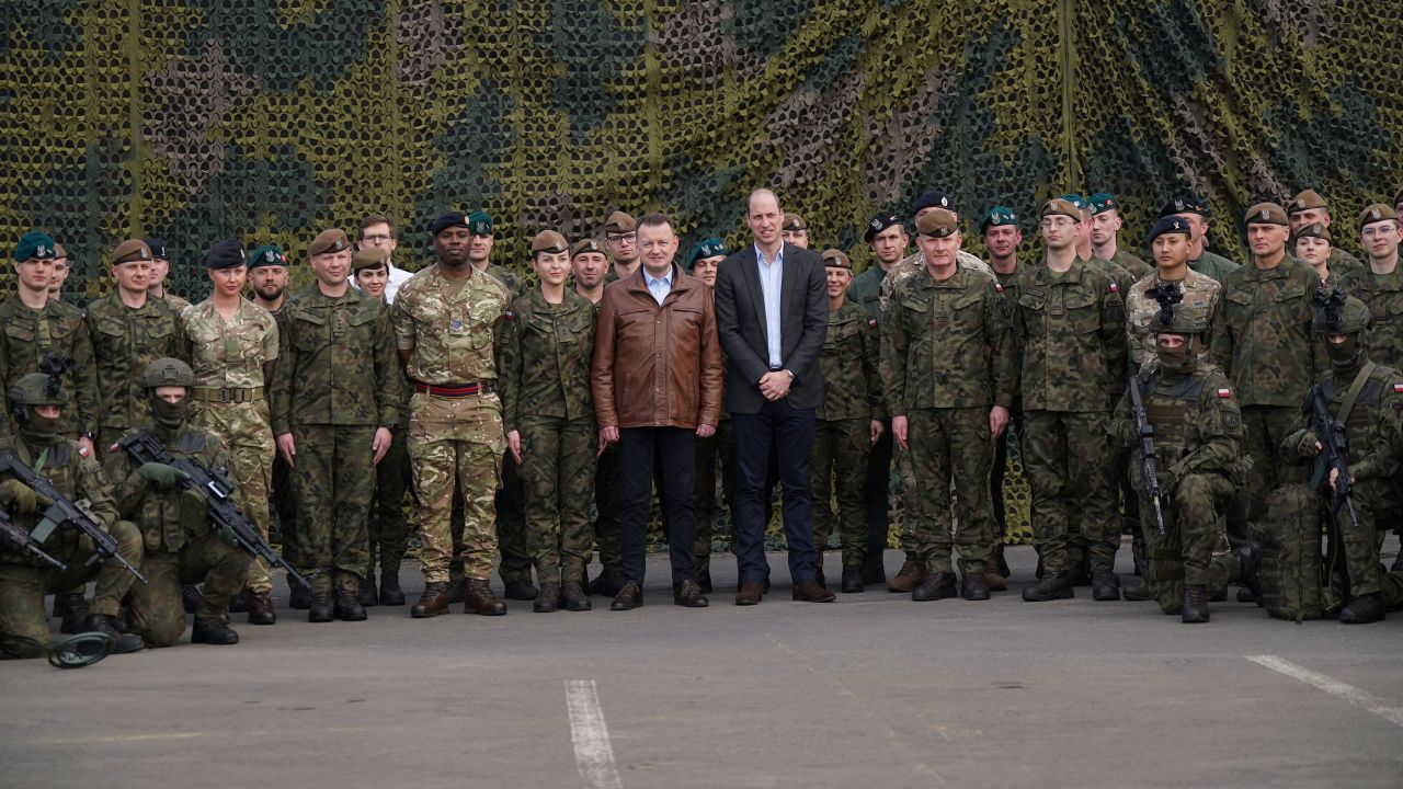 Książę William i polski wicepremier i minister obrony Mariusz Błaszczak (w środku po lewej) pozują do wspólnego zdjęcia z siłami brytyjskimi i polskimi.