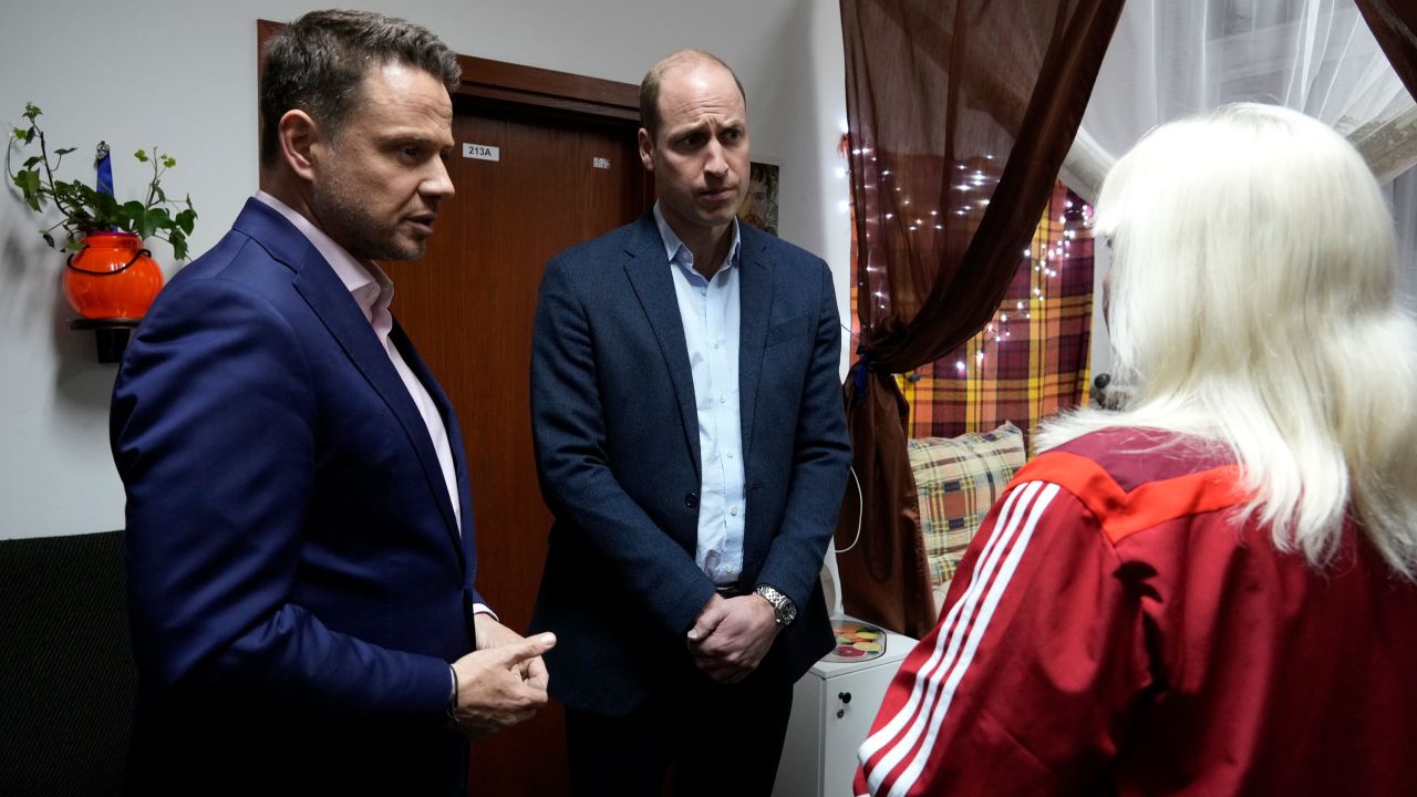 Prince William, center, and Mayor of Warsaw Rafal Trzaskowski, left, talk to an Ukrainian woman, who fled the war, during their visit to an accommodation centre in Warsaw, Poland on Wednesday evening.