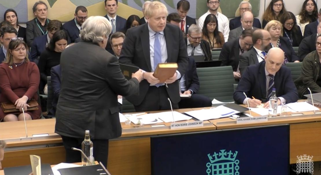 Boris Johnson takes an oath before heated exchanges at the parliamentary hearing on Wednesday.