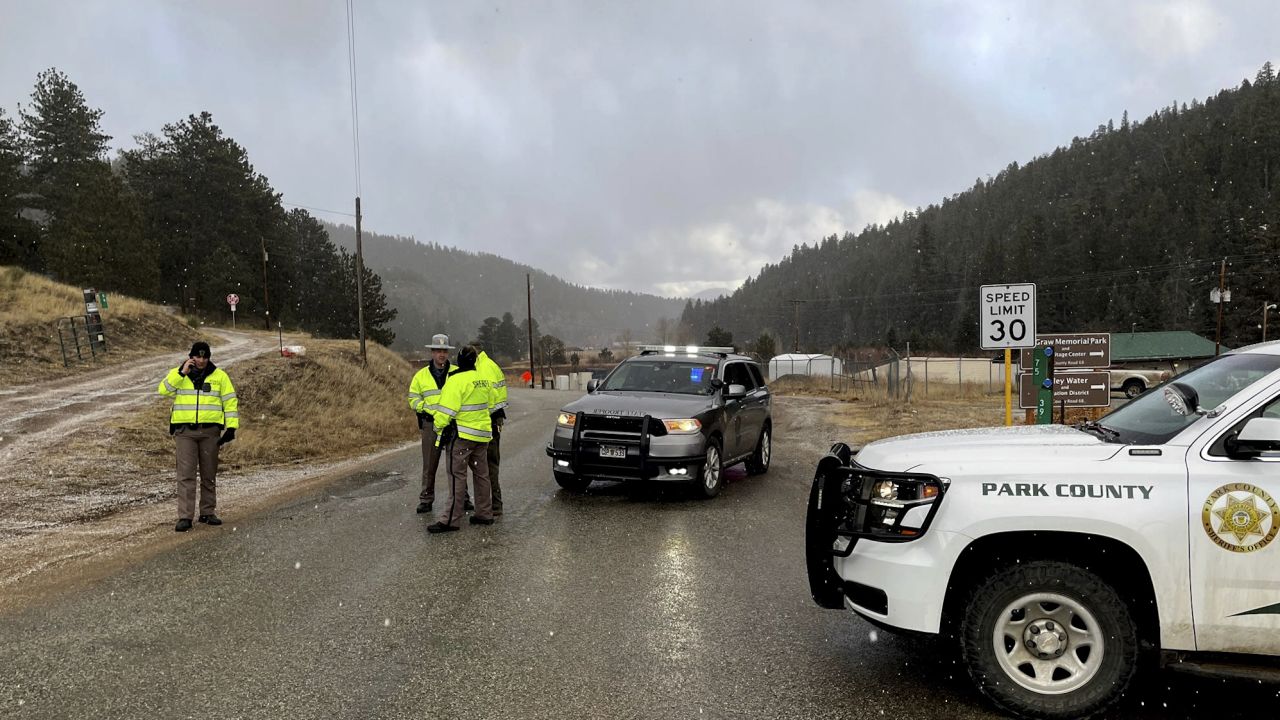 Deputies block a road in the town of Bailey, Colorado, where authorities found an abandoned car that belonged to the suspect in the shooting of two administrators at a Denver high school Wednesday.
