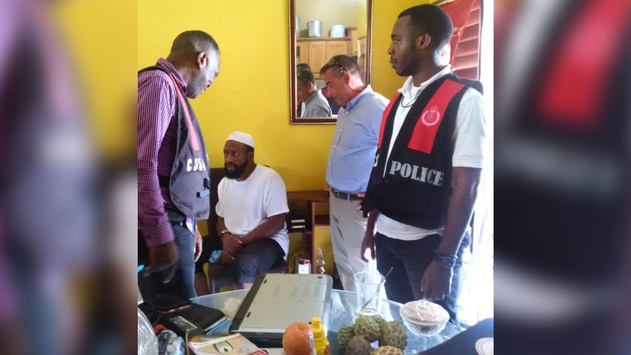 Thomas Galati de la policía de Nueva York, segundo desde la derecha, supervisa el arresto de Abdullah el-Faisal, sentado, en Jamaica en 2017. 
