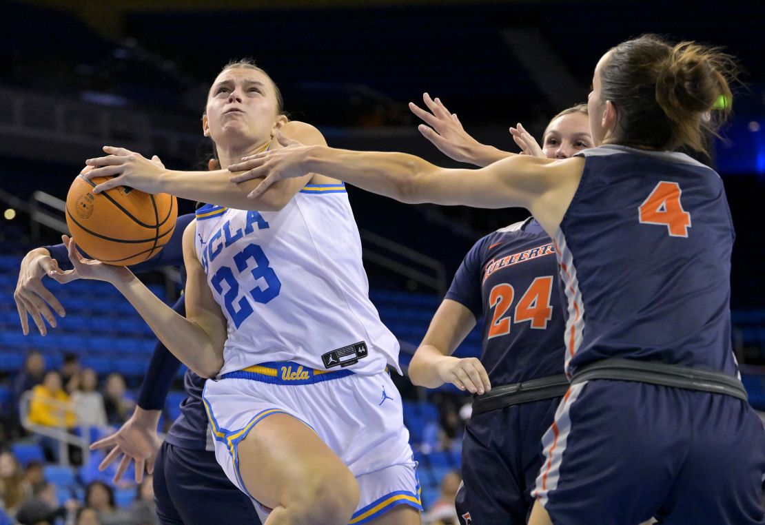 Gabriela Jaquez is fouled by Aixchel Hernandez as she drives past Kathryn Neff and Gabi Vidmar of the CSU Fullerton Titans on December 10, 2022. 