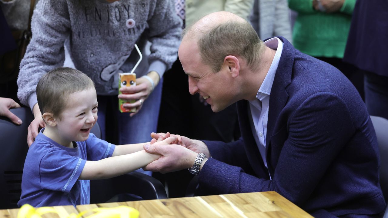 The Prince of Wales holds hands with Tymofii, 4, as he speaks with Ukrainian residents about their experiences of moving to Poland at an accommodation centre in Warsaw on Wednesday evening.