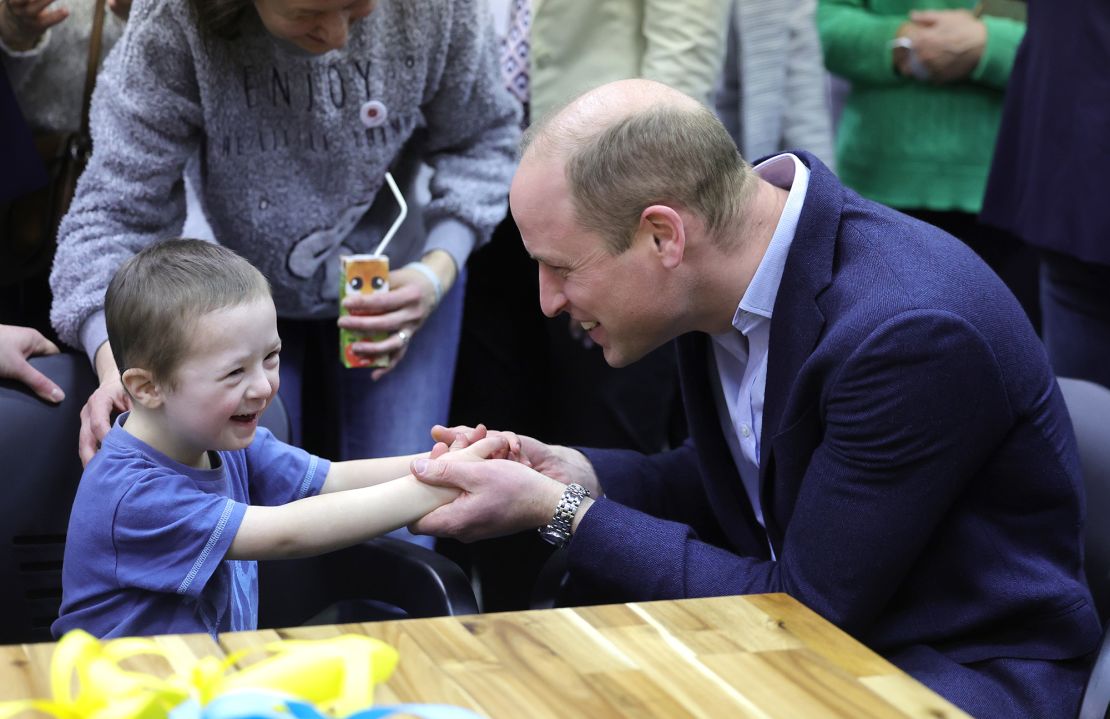 The Prince of Wales holds hands with Tymofii, 4, as he speaks with Ukrainian residents about their experiences of moving to Poland at an accommodation centre in Warsaw on Wednesday evening. 