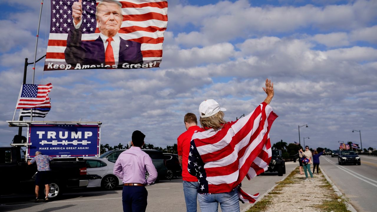 Evelyn Knapp, a supporter of former President Donald, waves to passersby outside of Trump's Mar-a-Lago estate on March 20, 2023, in Palm Beach, Florida. 