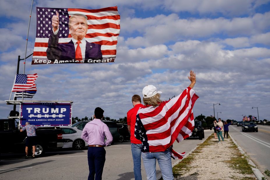 Evelyn Knapp, a supporter of former US President Donald Trump, waves to passersby outside of Trump's Mar-a-Lago estate in Palm Beach, Florida, on Monday, March 20. Trump is <a href="https://www.cnn.com/politics/live-news/trump-legal-developments-03-23-23/index.html" target="_blank">the subject of several major investigations</a> as he forges ahead with his 2024 presidential campaign, and <a href="https://www.cnn.com/2023/03/18/politics/donald-trump-manhattan-da-arrest-protests/index.html" target="_blank">he said last weekend that he expected to be arrested</a> in connection with the yearslong investigation into a hush money scheme involving adult film actress Stormy Daniels. But as of Thursday, no decisions on charges had been made by Manhattan district attorney Alvin Bragg.