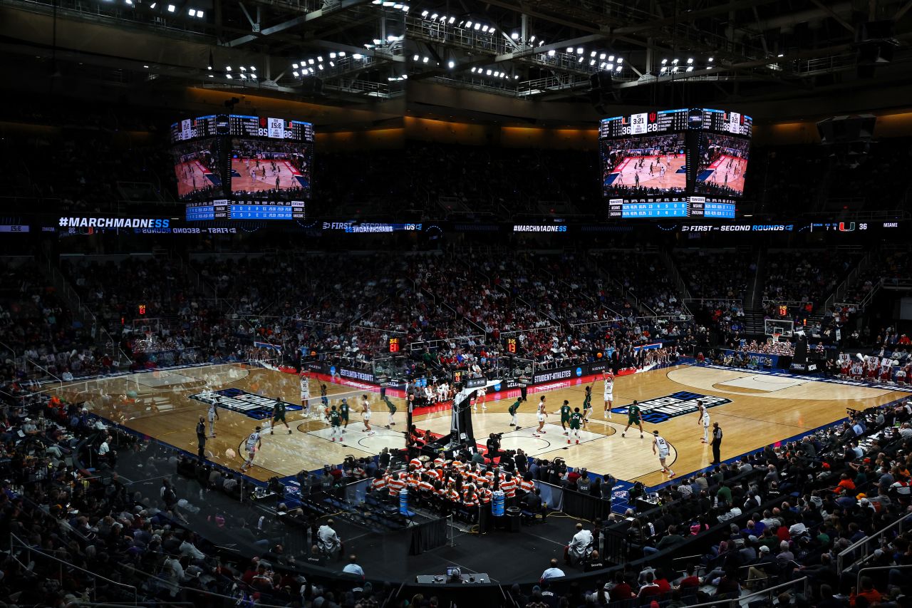 Players from Indiana and Miami are reflected off the glass of a suite during an NCAA Tournament game in Albany, New York, on Sunday, March 19.