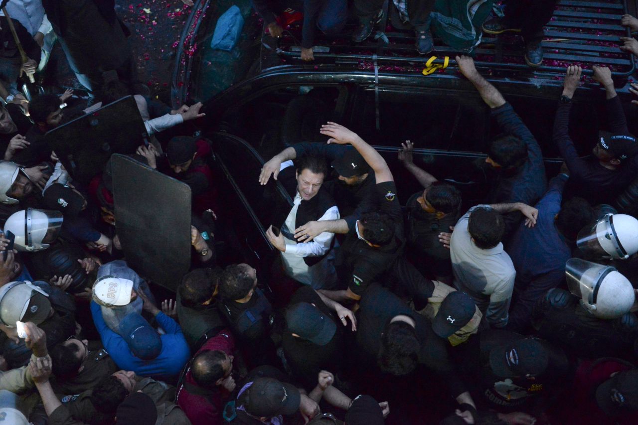 Security personnel make way for former Pakistani Prime Minister Imran Khan, center, as he arrives to appear in court in Lahore, Pakistan, on Friday, March 17. A top Pakistani court suspended an arrest warrant for Khan, giving him a reprieve to travel to Islamabad and <a href="https://www.cnn.com/2023/03/18/asia/imran-khan-high-court-intl-hnk/index.html" target="_blank">face charges in a graft case</a> without being detained.