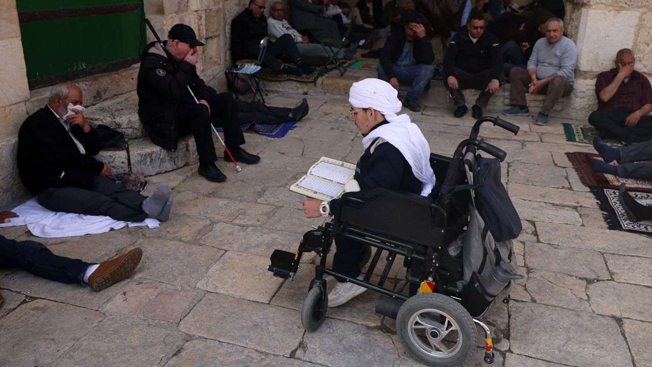 A disabled man reads the Quran as people gather at the Al Aqsa mosque compound in Jerusalem, before the start of the first Friday noon prayer of the Islamic fasting month of Ramadan, on Thursday.