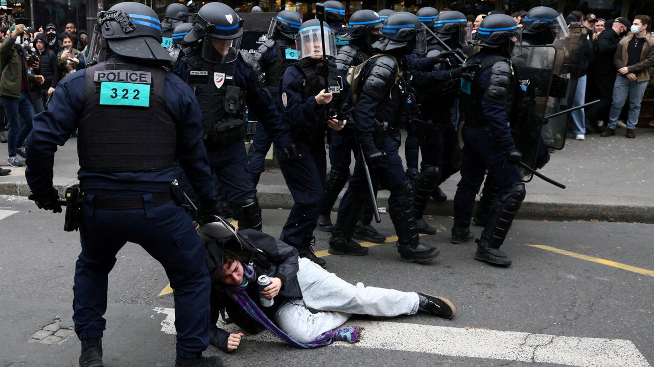 French riot police apprehend a protester amid clashes during a demonstration against pension reform in Paris on March 23, 2023.  