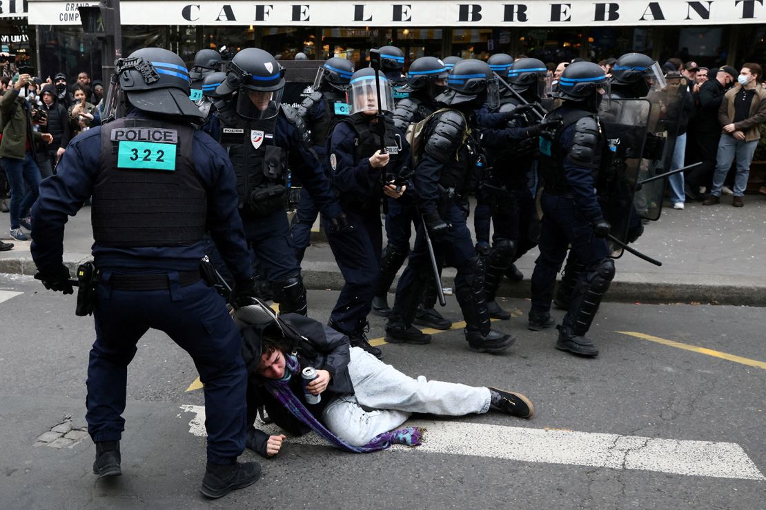 French riot police apprehend a protester amid clashes during a demonstration against pension reform in Paris on March 23, 2023.  