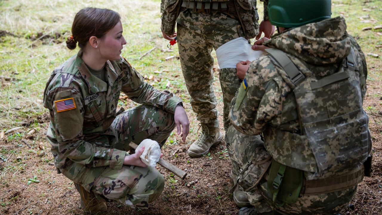 US Army Staff Sgt. Desirie Carson, a combat medic specialist assigned to Task Force Orion, 27th Infantry Brigade Combat Team, New York Army National Guard, instructs Armed Forces of Ukraine soldiers on how to apply a tourniquet during "all service member" medical training in Grafenwoehr, Germany, February 23, 2023. 