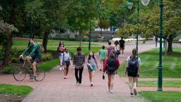 Students walk to and from classes on the Indiana University campus, Thursday, Oct. 14, 2021, in Bloomington, Ind. 