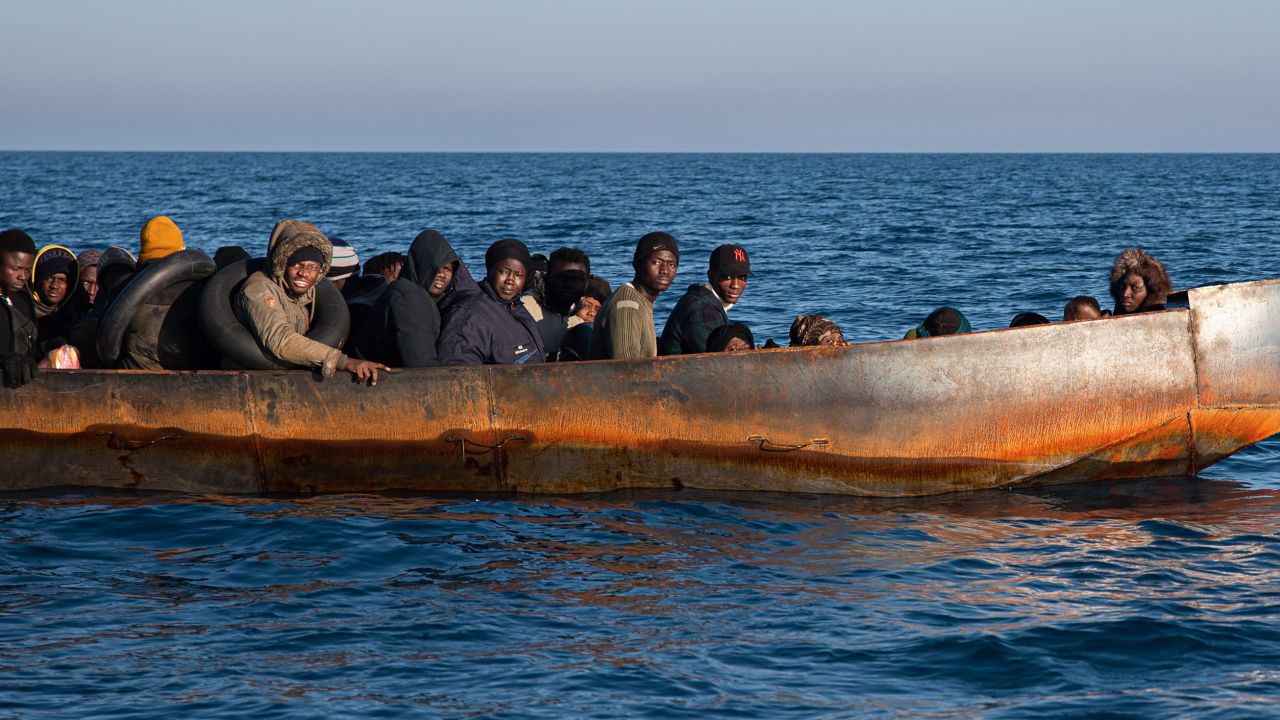 Migrants in Lampedusa await life jackets from a rescue team on February 21, 2023.