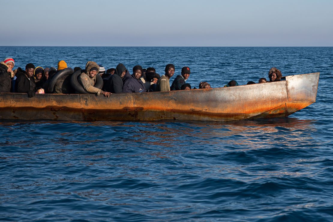 Migrants in Lampedusa await life jackets from a rescue team on February 21, 2023. 