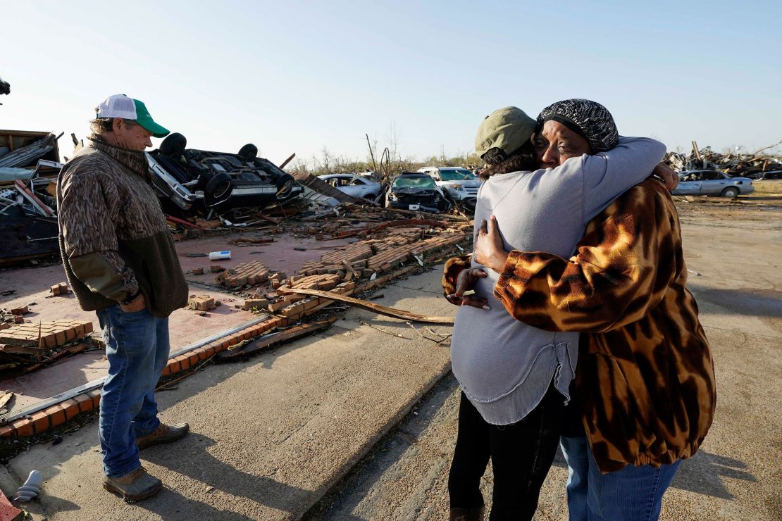 Tracy Hardin, center, who with her husband Tim, left, own Chuck's Dairy Bar, consoles a neighbor in Rolling Fork, Mississippi.