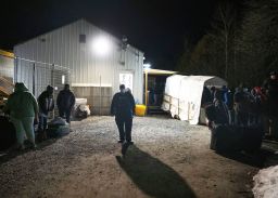 A Royal Canadian Mounted Police officer pulls a family of asylum-seekers, left, aside after they crossed the border just after the midnight deadline at Roxham Road from New York into Canada, early Saturday, March 25, 2023, in Champlain, N.Y.