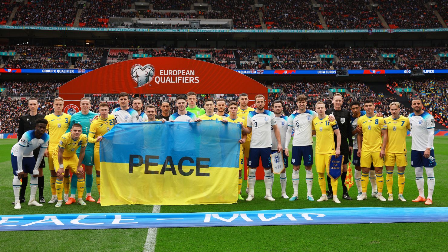 Players from both side's pose for a photograph with a Ukraine flag with the word Peace on prior to the Euro 2024 qualifying match on March 26, 2023.
