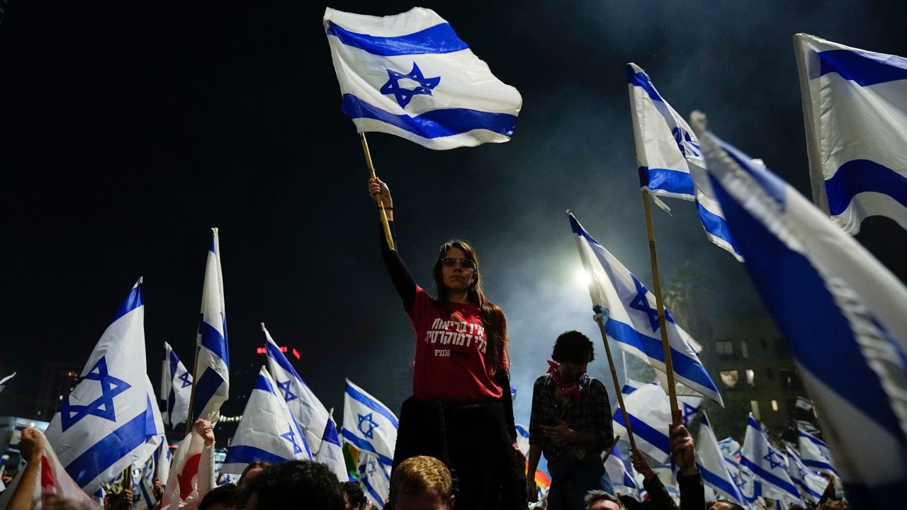 Thousands streamed into central Tel Aviv on Sunday night in support of the fired defense minister