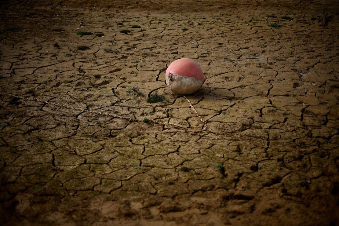 A buoy is seen on the banks of the partially dry Lake Montbel as France faces a record winter dry spell.