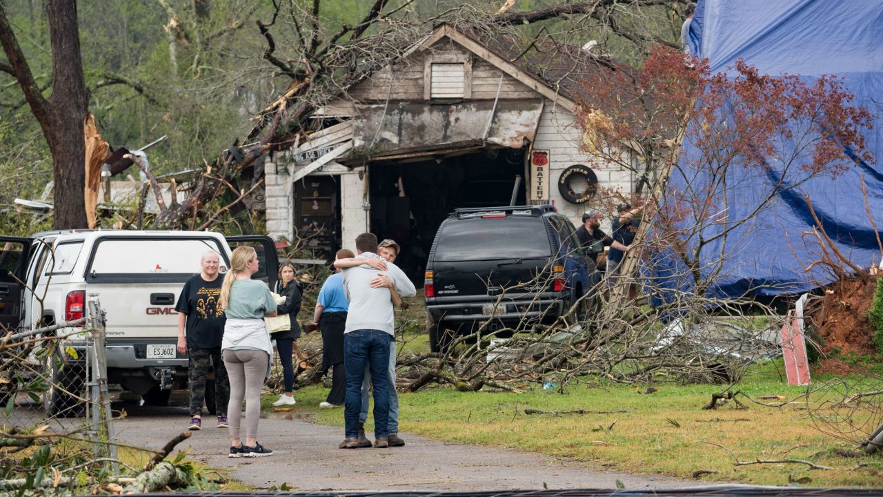 Family members outside their damaged home after a tornado touched down Sunday in West Point, Georgia.