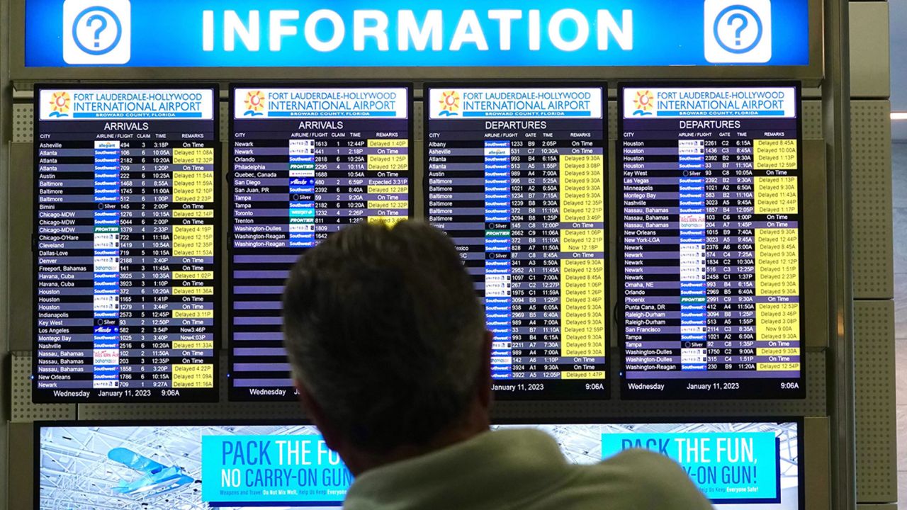 A man looks at the flight information board at Fort Lauderdale-Hollywood International Airport after an early morning FAA system outage caused delays across the country in January. Such incidents are making some people think twice before booking flights.