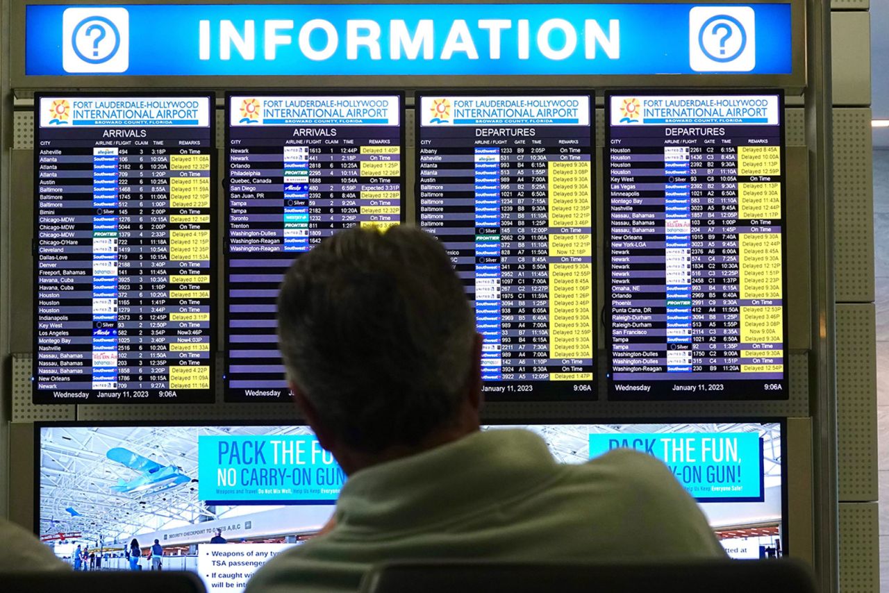 A man looks at the flight information board at Fort Lauderdale-Hollywood International Airport after an early morning FAA system outage caused delays across the country in January. Such incidents are making some people think twice before booking flights.