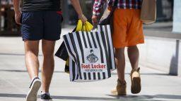Customers walk with Foot Locker Inc. shopping bags on the Third Street Promenade in Santa Monica, California, U.S., on Tuesday, Aug. 16, 2016.