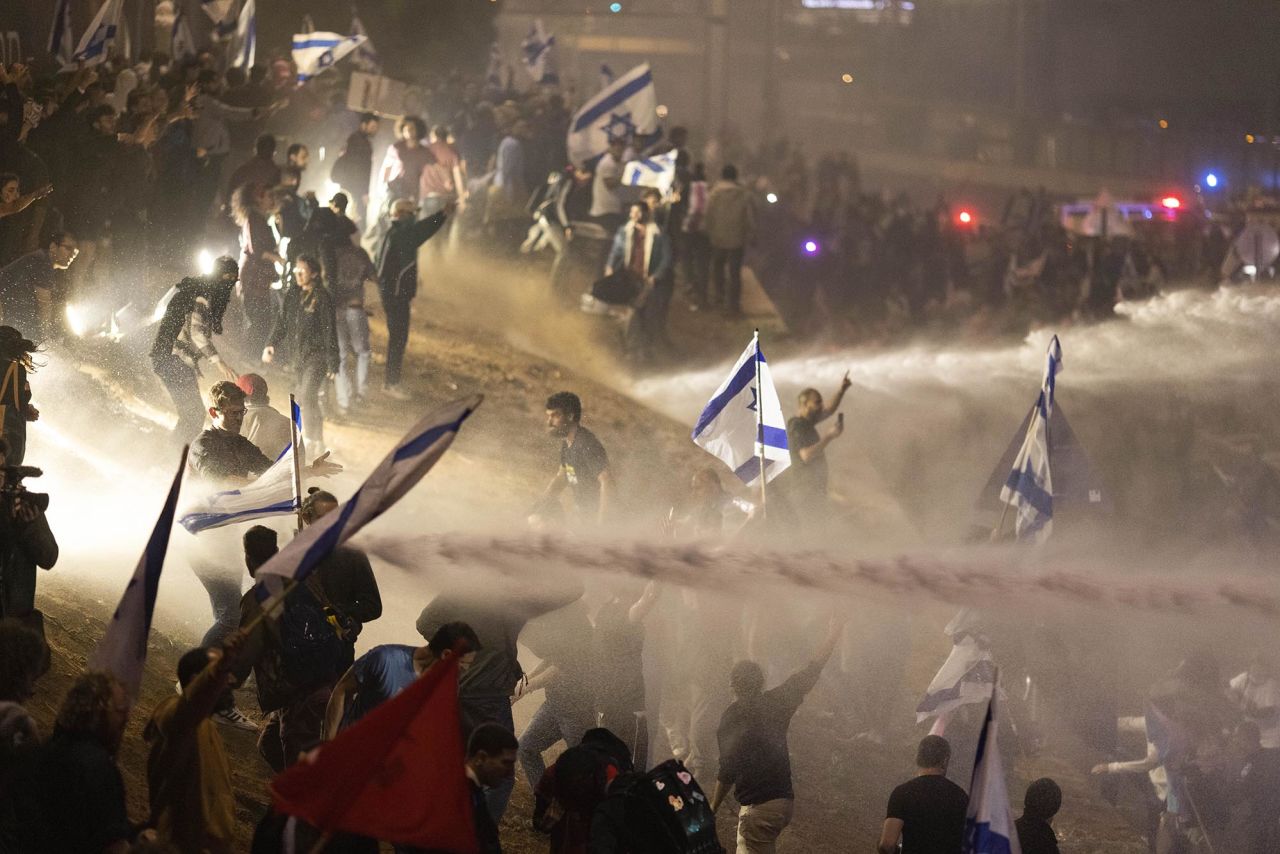 Police use a water cannon to disperse demonstrators blocking a highway in Tel Aviv on March 27.
