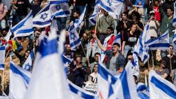 Protestors wave flags as thousands of Israelis attend a rally against Israeli Government's judicial overhaul plan on March 27, 2023 in Jerusalem, Israel. 