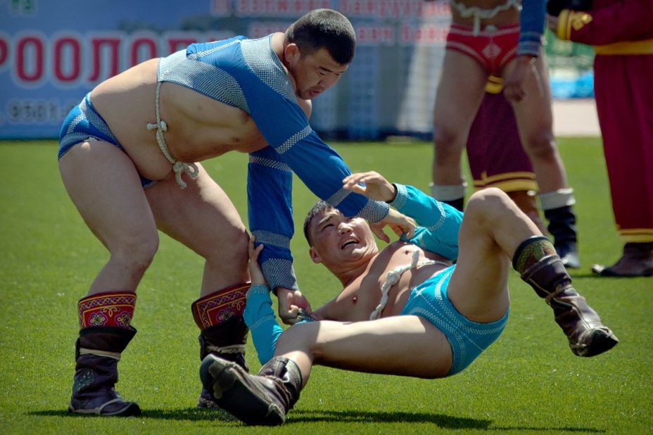 <strong>Naadam Festival: </strong>A wrestler is thrown to the ground by his opponent during the annual Naadamm festival in Ulaanbaatar. The famed event is held every July to celebrate the anniversary of Genghis Khan's march to world conquest. The sports festival, which turned 100 in 2022, features traditional Mongolian events including wrestling, archery and horse racing.  