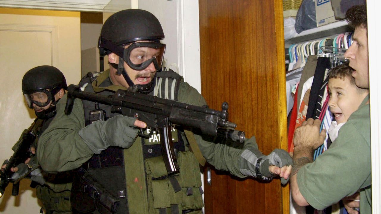 In this April 22, 2000, file photo by Associated Press photojournalist Alan Diaz, Elian Gonzalez is held in a closet by Donato Dalrymple, right, as government officials search for the boy in his relative's home in Miami.
