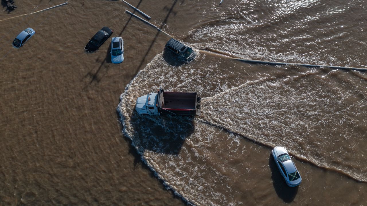 CORCORAN, CA - MARCH 24: In an aerial view, a truck drives between cars stranded in a flood as a series of atmospheric river storms melts record amounts of snow in the Sierra Nevada Mountains on March 24, 2023 near Corcoran, California. The once-massive Tule Lake disappeared as faming diverted its waters and developed on the rich soils of the lakebed. As levees become unable to hold back the floods, speculation is rising that the lake will be reborn.