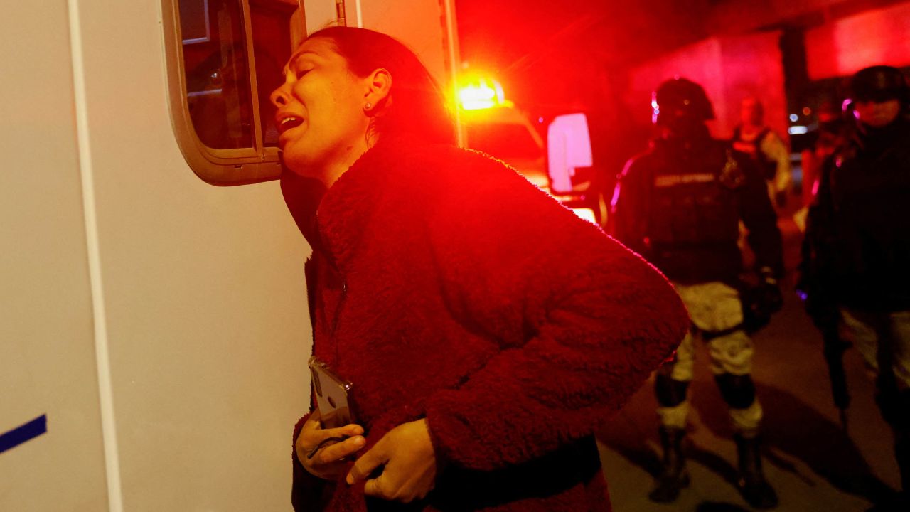 Viangly, a Venezuelan migrant, reacts outside an ambulance for her injured husband Eduard Caraballo while Mexican authorities and firefighters remove injured migrants  from inside the National Migration Institute building.