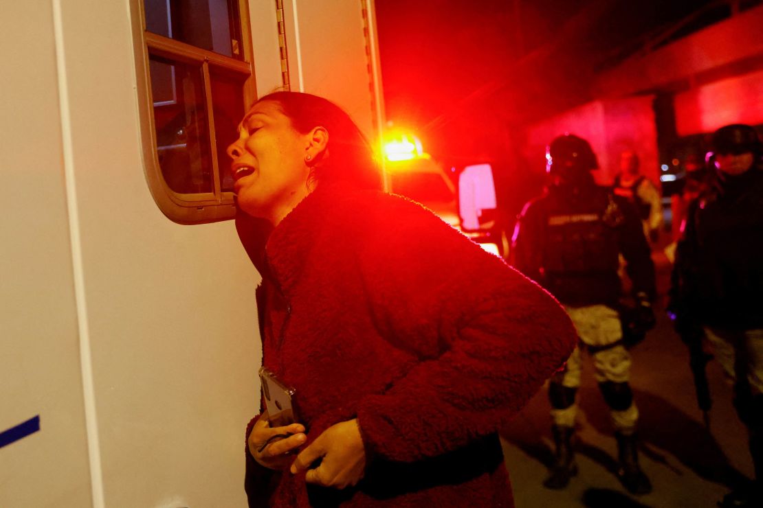 Viangly Infante, a Venezuelan migrant, reacts outside an ambulance for her injured husband Eduard Caraballo while Mexican authorities and firefighters remove injured migrants  from inside the National Migration Institute building.