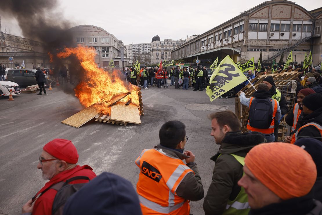 Striking railway workers demonstrate near burning palettes at the Gare de Lyon railway station.