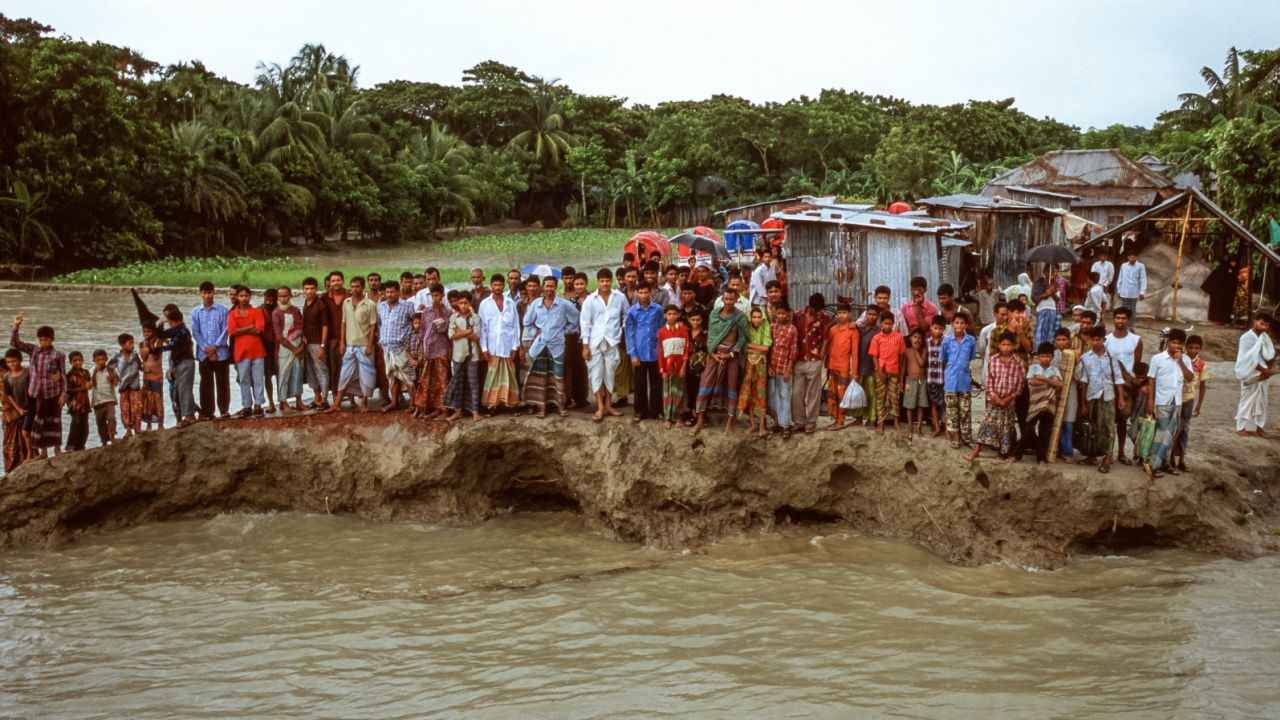 Villagers stand on a remnant of a road in Bhola Island, Bangladesh, in 2005. The area, at the mouth of the Ganges delta, is still suffering from accelerated erosion due to sea level rise. 