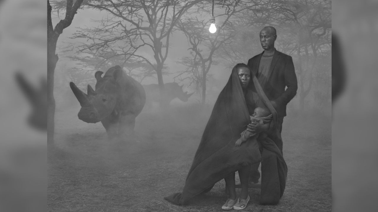 Alice, Stanley and their child were displaced as floods destroyed their house in Kenya in 2017. They are photographed at the Ol Pejeta Conservancy together in the same frame as Najin, one of the last two northern white rhinos in the world. It's part of photographer Nick Brandt's