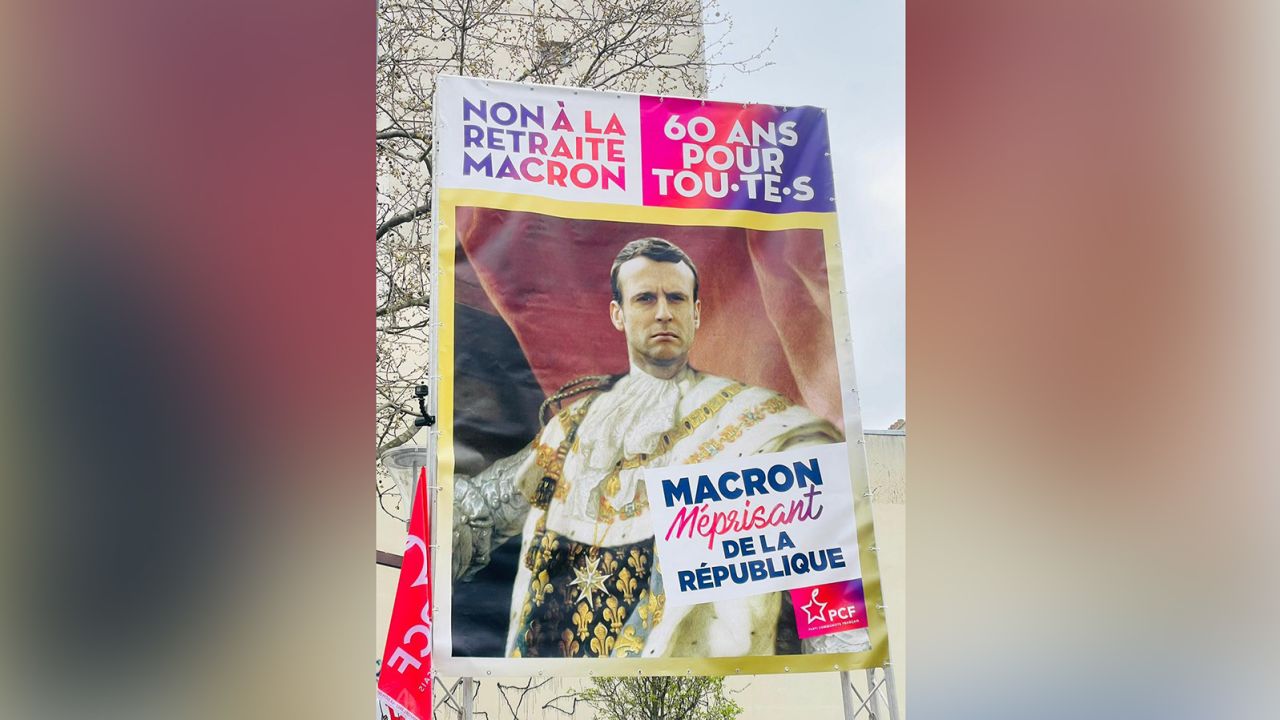A poster of President Emmanuel Macron is waved at protests in Paris on Tuesday. It reads,