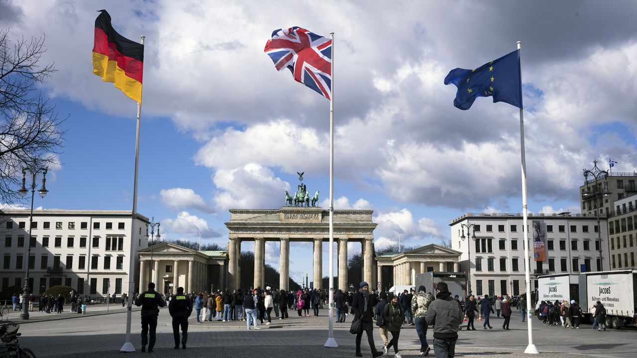 Soldan, Alman bayrağı, Union Jack bayrağı ve Kral Charles'ın Almanya ziyaretinin arifesinde Brandenburg Kapısı önünde Avrupa Birliği bayrağı.