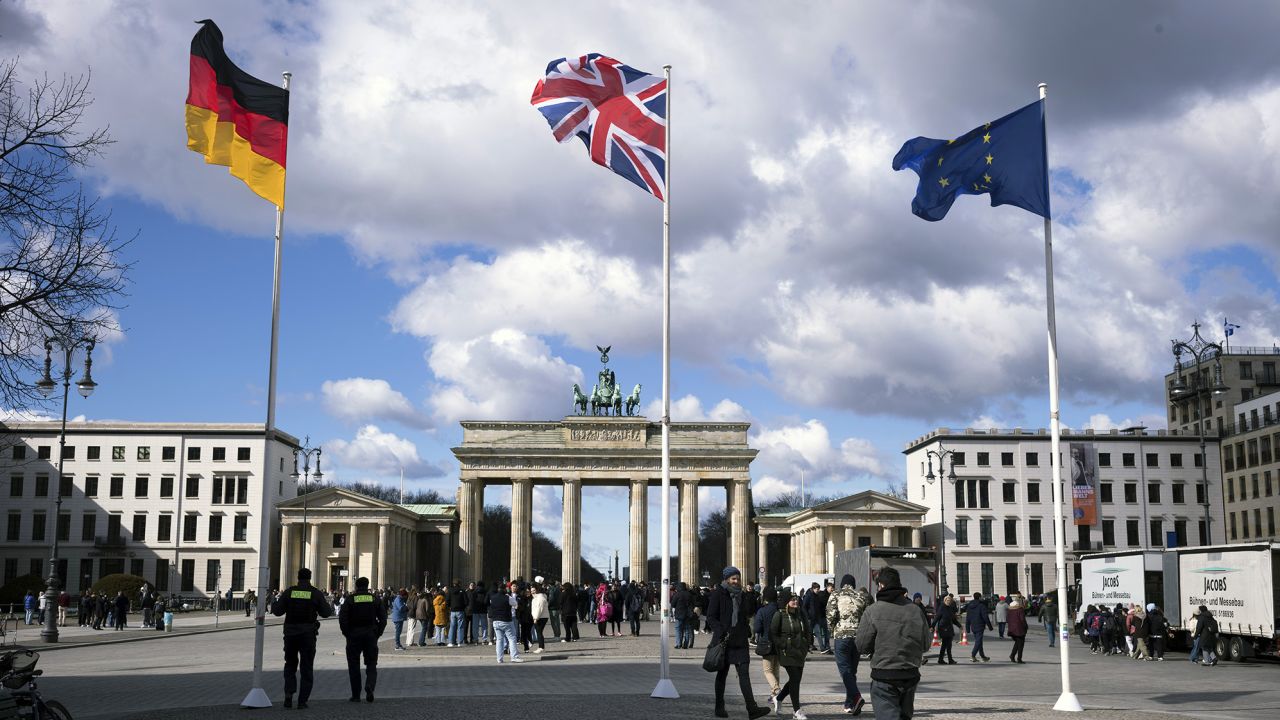 Desde la izquierda, la bandera alemana, la bandera Union Jack y la bandera de la Unión Europea frente a la Puerta de Brandeburgo en la víspera de la visita del rey Carlos a Alemania.