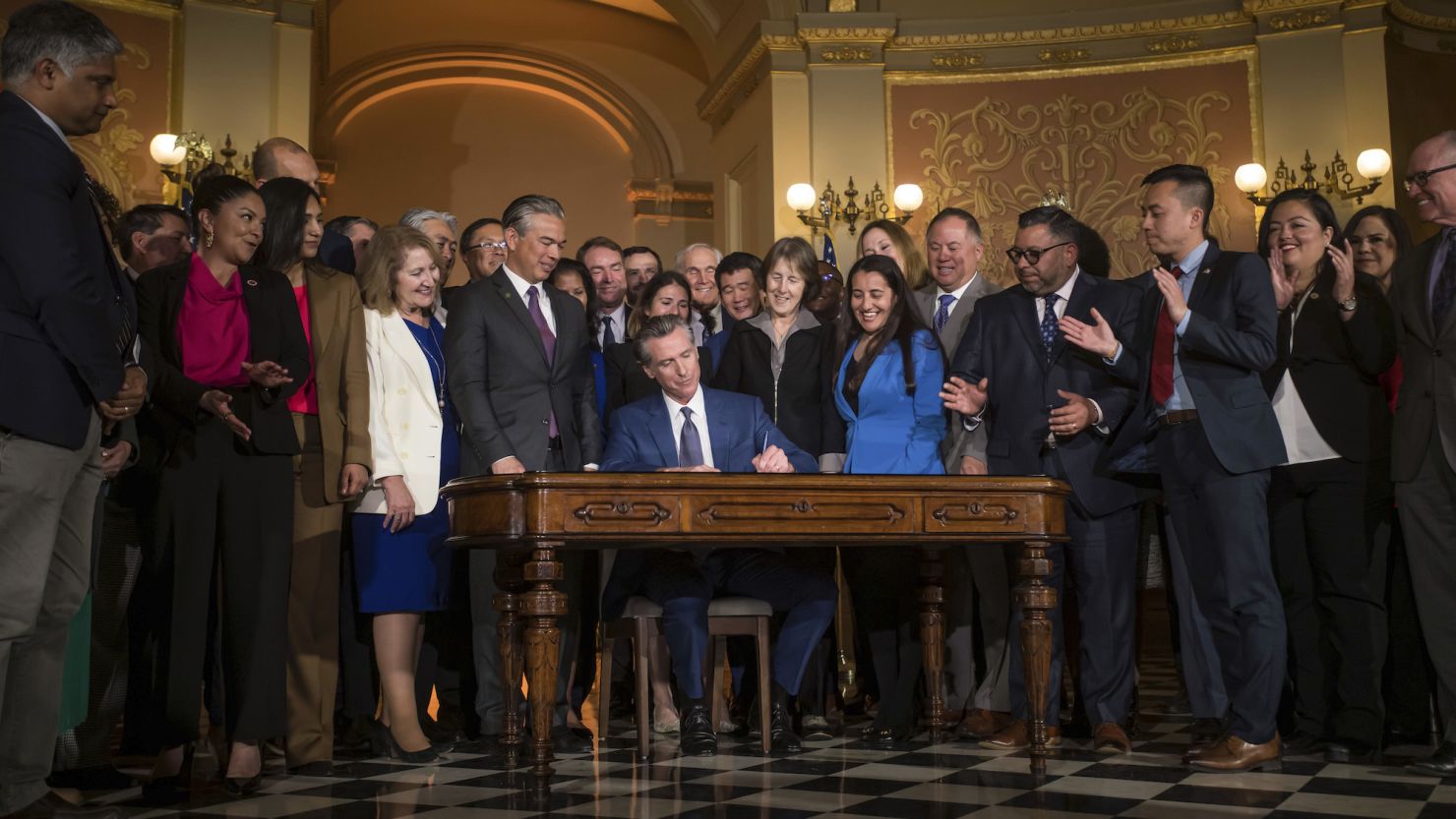 Gov. Gavin Newsom signs a bill aimed at addressing gas price gouging while surrounded by legislators and state officials in the Capitol rotunda, Tuesday, March 28, 2023, in Sacramento, Calif.