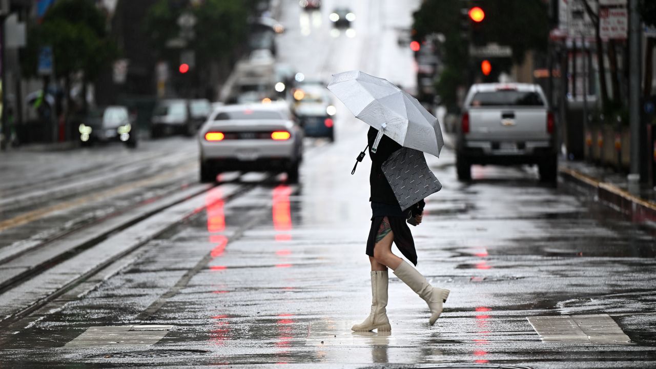 A person walks with an umbrella on California Street during a rainy day in San Francisco on Tuesday.