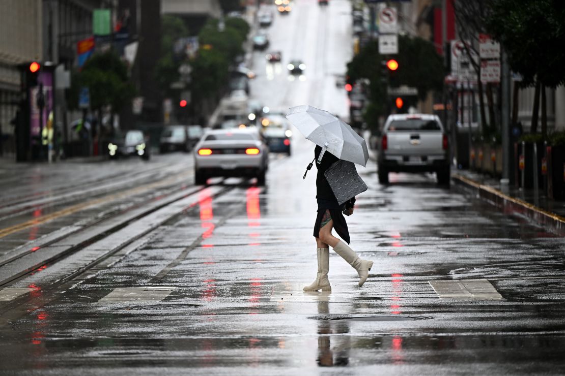 A person walks with an umbrella on California Street during a rainy day in San Francisco on Tuesday.