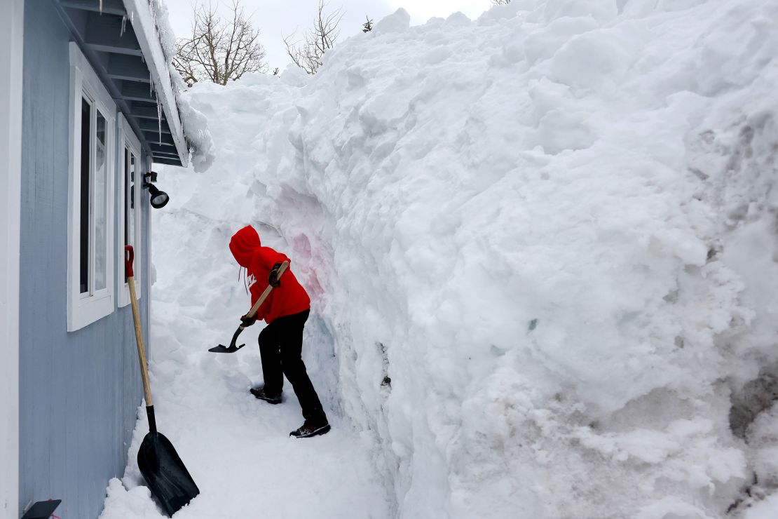 Robert Mendoza shovels out his neighbor's home in the Sierra Nevada mountains on Tuesday in Mammoth Lakes, California. 